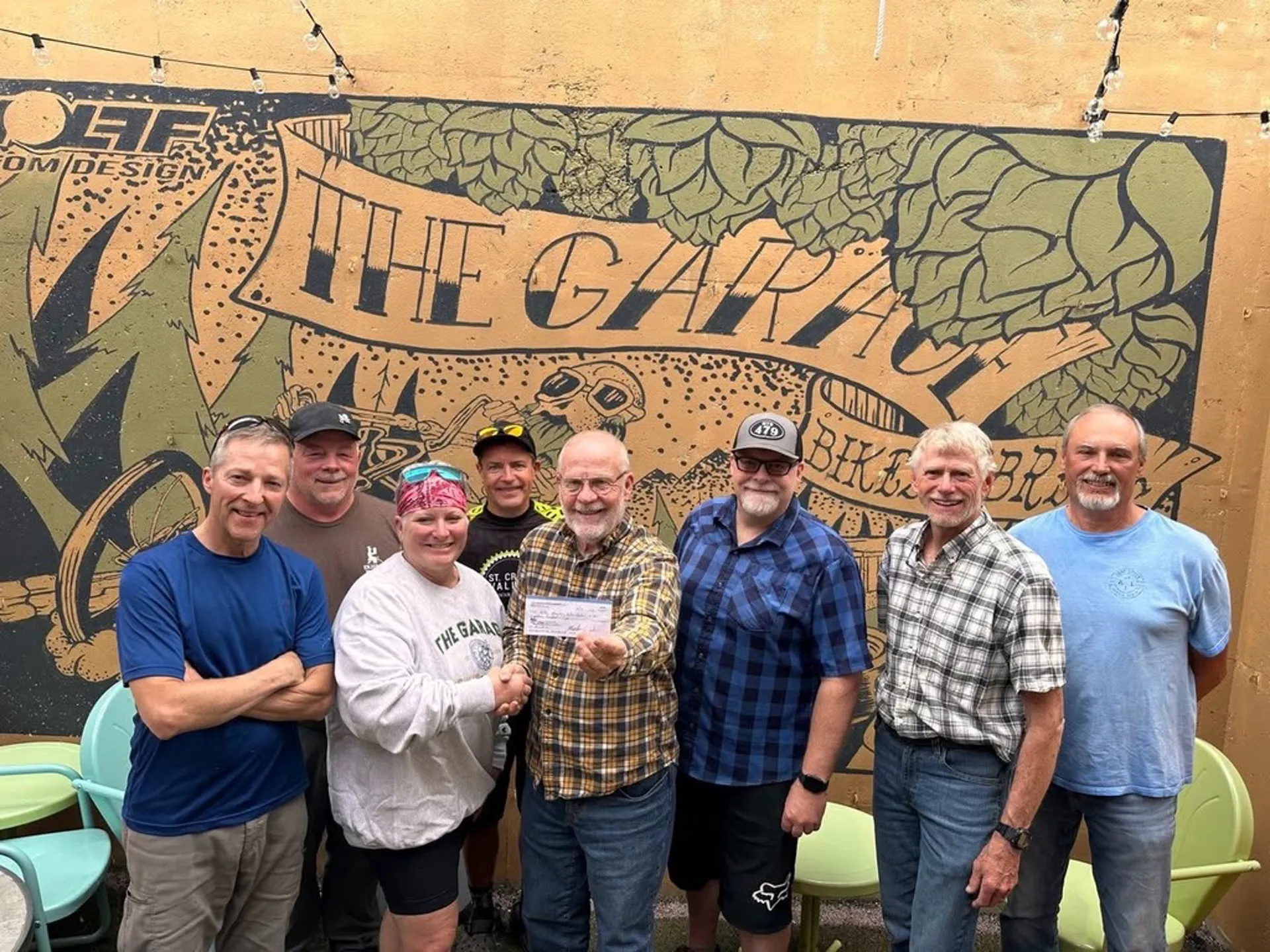 Community cheque handover in front of The Garage mural