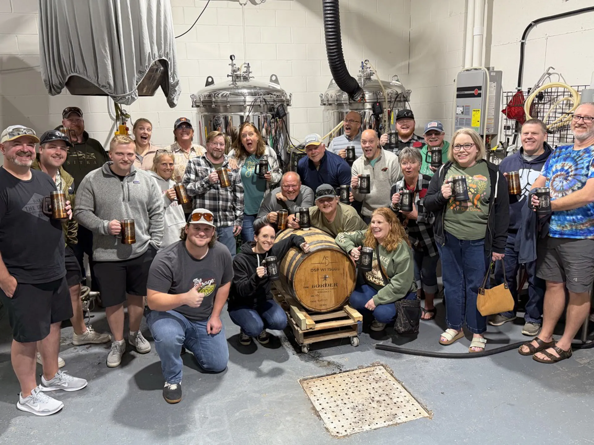 Group raising mugs in the brewery