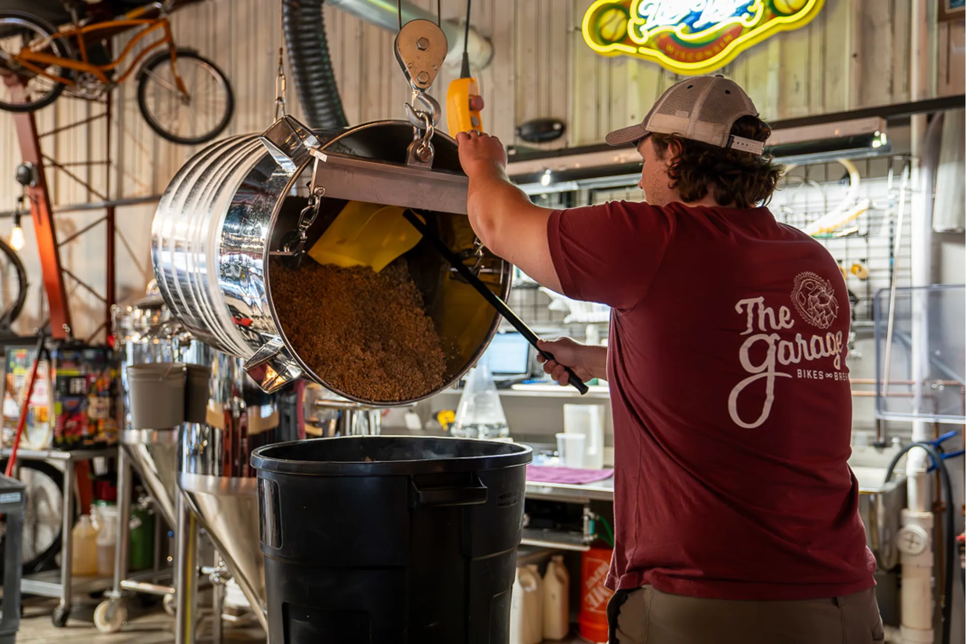 Brewer emptying spent grain from the mash tun
